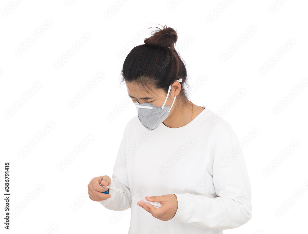 Female patient wearing a mask holding a mercury thermometer in hand ready to measure Female patient wearing a mask holding a mercury thermometer in hand ready to measure