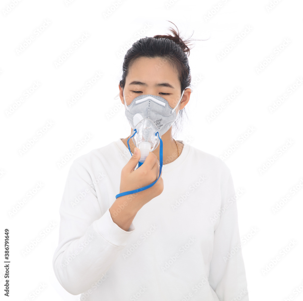 A woman wearing a mask holds a medical atomized inhalation mouth cover in hand