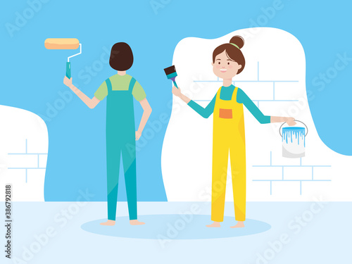 couple with paint roller brush and bucket blue wall remodeling