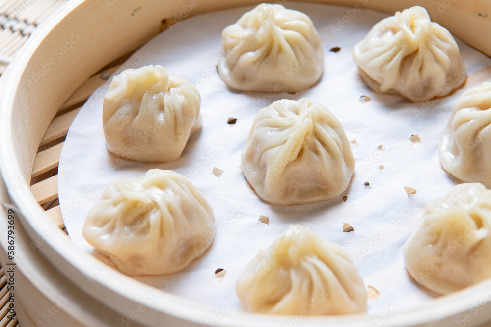 Steamed xiaolongbao served in a traditional steaming basket (.close up) Steamed xiaolongbao served in a traditional steaming basket (.close up)