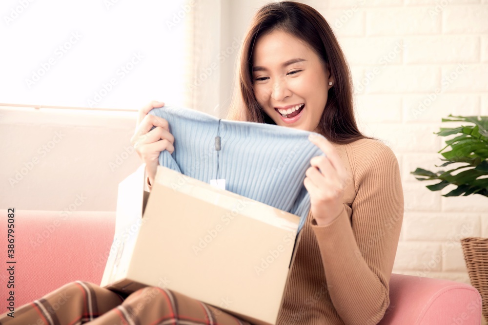 Beautiful woman unboxing a new cloth delivered Beautiful woman unboxing a new cloth delivered