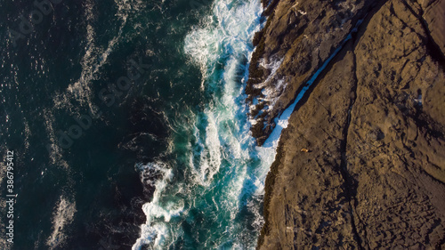 Aerial views of amazing waves tossing by rocks in the ocean. Wallpaper design. Fantastic landscape. Beauty of nature concept. Top view.