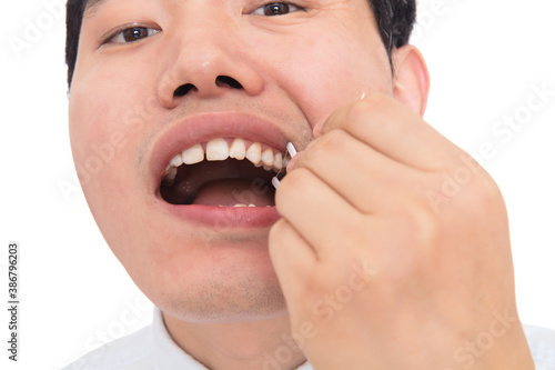 Close-up of man flossing teeth