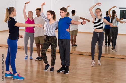 Group of positive russian teen dancing salsa in dance studio