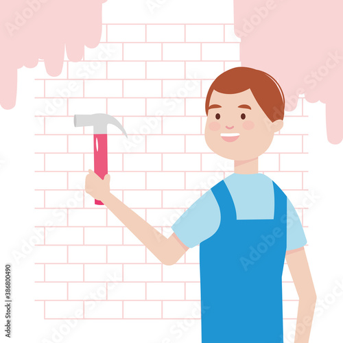 worker carpenter with hammer and wall with pink paint remodeling