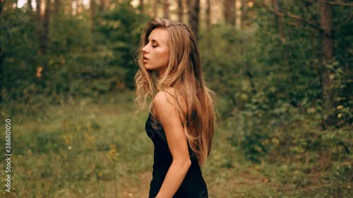 A frightened young lost woman in a dress in the forest. A beautiful girl is looking around and running away from someone in the woods among the trees.