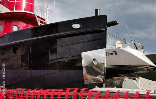 Nave e barca a vela incantiere riflessi acciaio metallo nero rosso riparazione photo