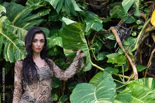 Portrait of young woman in green leaves