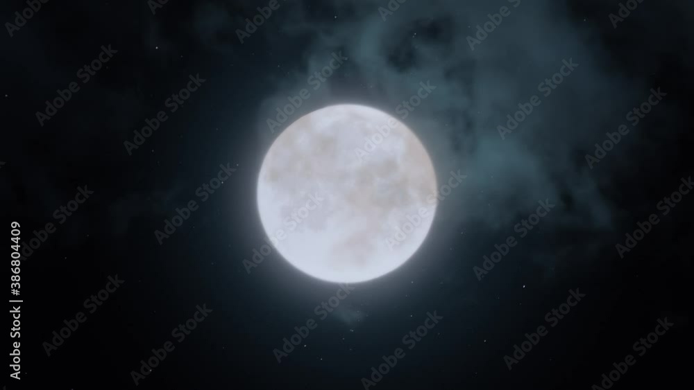 Big Blue Full Moon Rising In The Dark Sky. Halloween. Moon on a dark night with clouds moving over it close-up Big Blue Full Moon Rising In The Dark Sky. Halloween. Moon on a dark night with clouds moving over it close-up