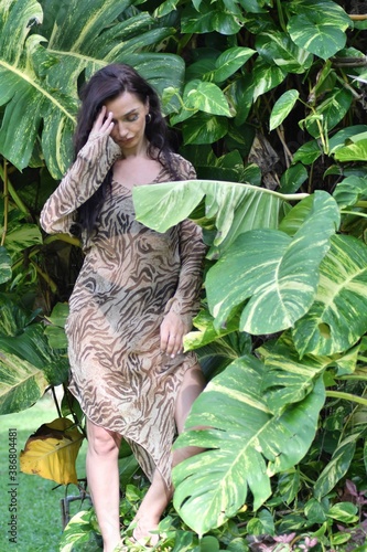 Face of Pacific Islander woman surrounded by wet leaves