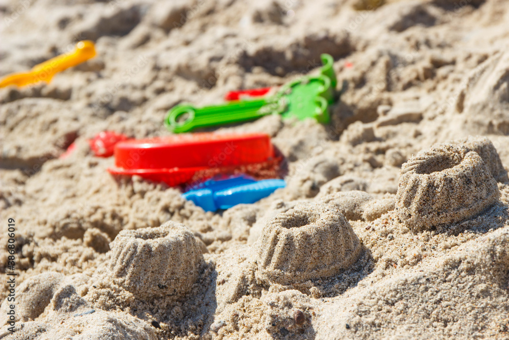 Different shapes made of sand and children toys for playing on beach. Summer, vacation time and child development Different shapes made of sand and children toys for playing on beach. Summer, vacation time and child development