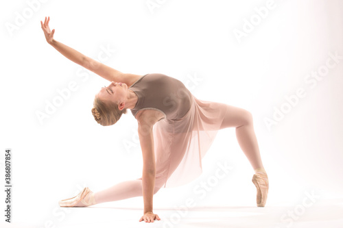 Young woman ballet dancer doing a lunge in the studio.