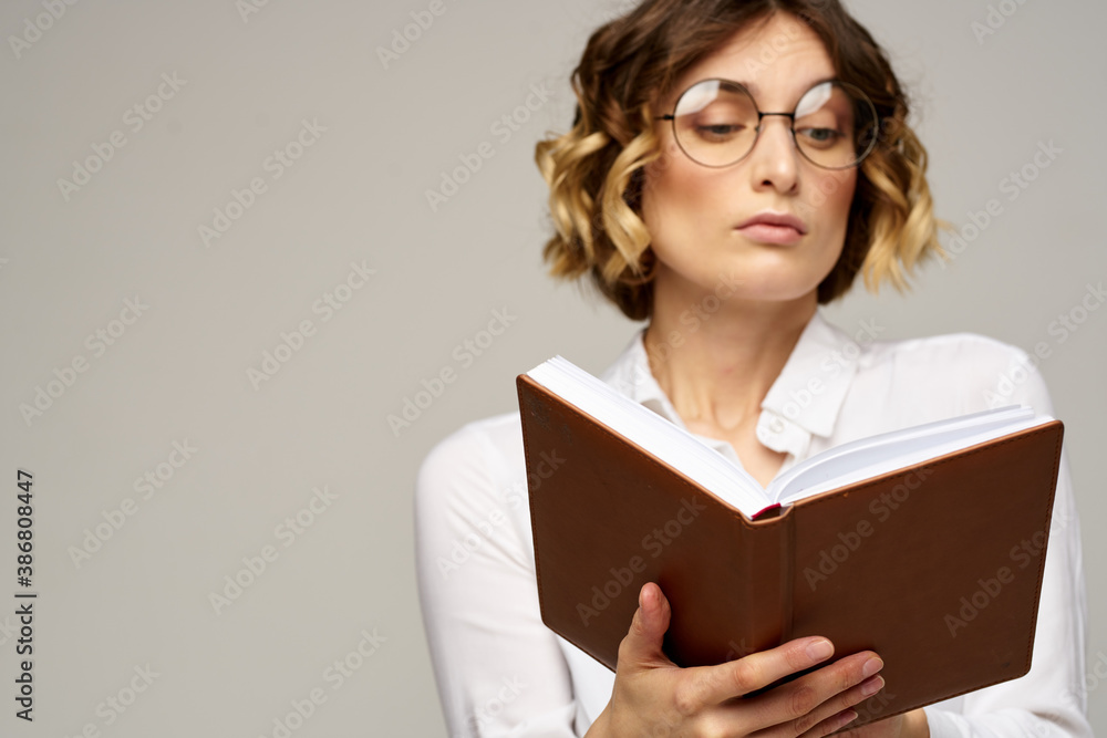 Business woman with notepad and glasses on a light background hairstyle success emotions Business woman with notepad and glasses on a light background hairstyle success emotions