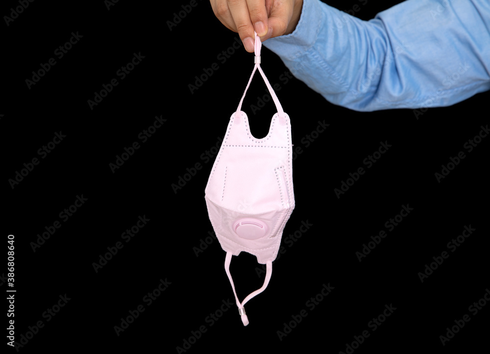 The man in front of a black background holds an N95 mask in his hand The man in front of a black background holds an N95 mask in his hand