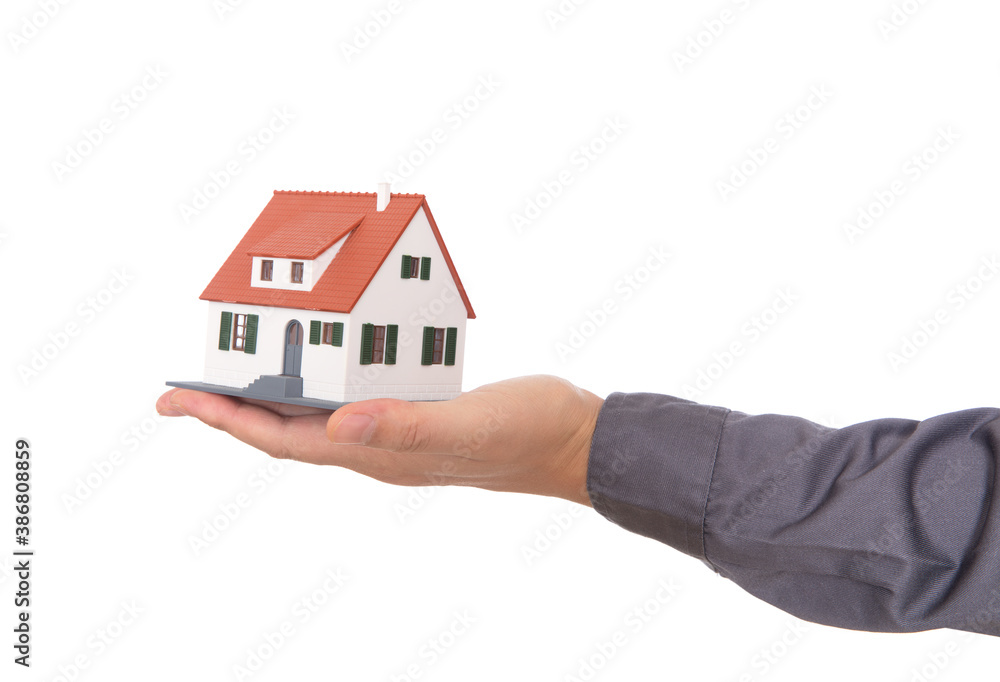 Closeup of hand holding house model in front of white background Closeup of hand holding house model in front of white background