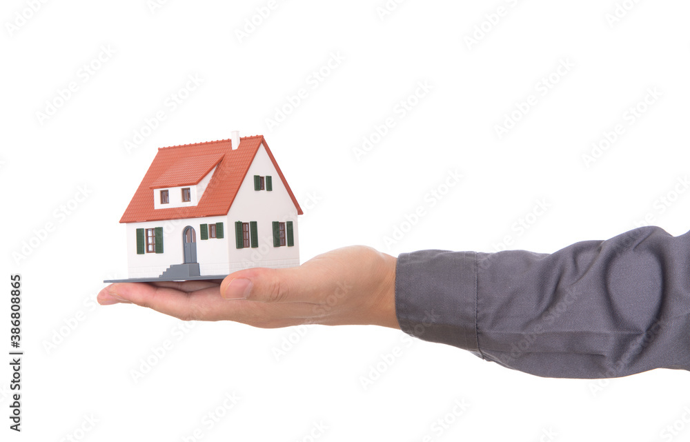 Closeup of hand holding house model in front of white background Closeup of hand holding house model in front of white background