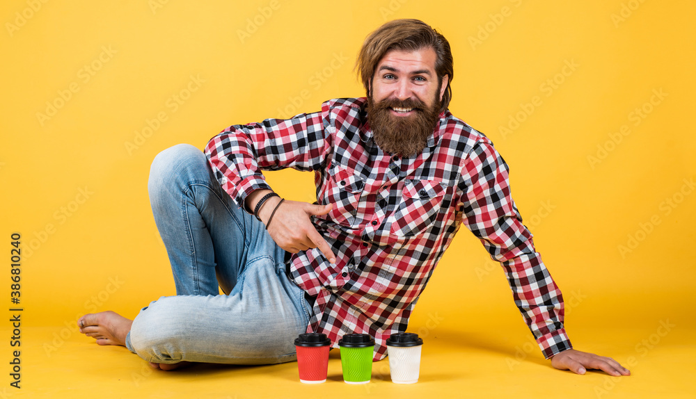 Fototapeta premium lifestyle concept. handsome hipster man with cup of take away coffee. he is taking coffee break. Handsome mature guy drinking from cup. Hold paper cup of coffee or tea