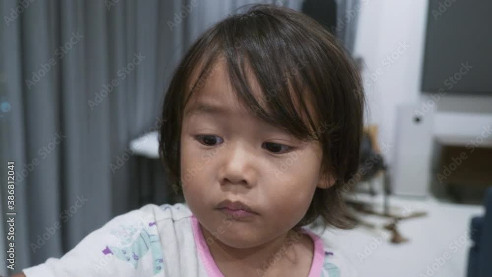 A mixed Asian toddler interacting with and watching an iPad from the POV of the iPad. A mixed Asian toddler interacting with and watching an iPad from the POV of the iPad.