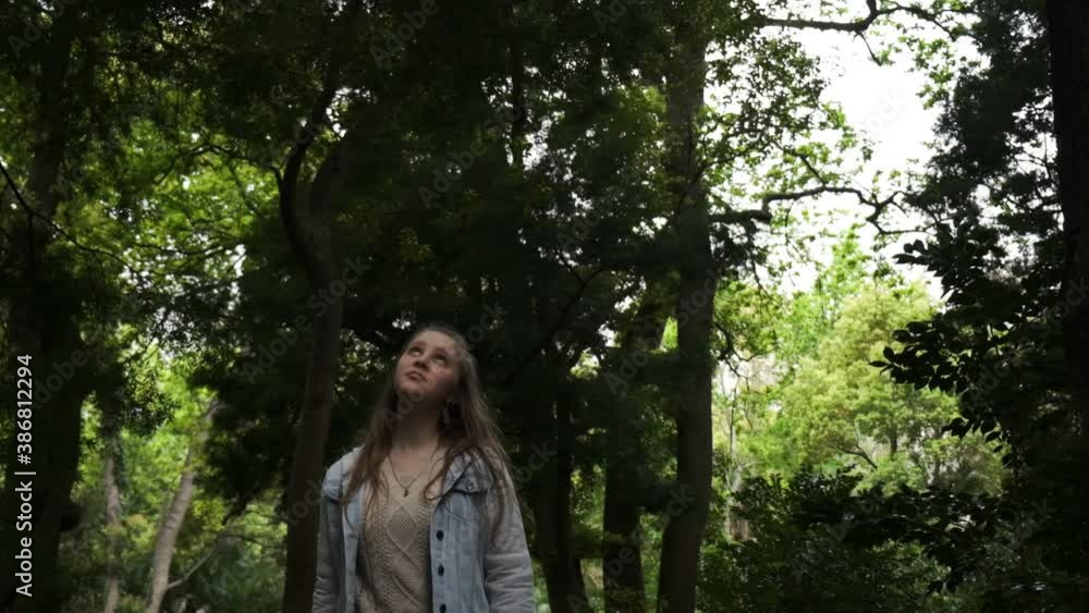 Young Caucasian female walking through woodland wilderness thinking concept slow motion Young Caucasian female walking through woodland wilderness thinking concept slow motion