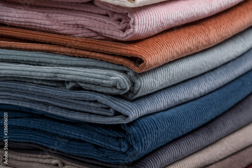 Multicolored fabrics folded in a stack . Multi-colored corduroy textile.  Velvet. photo