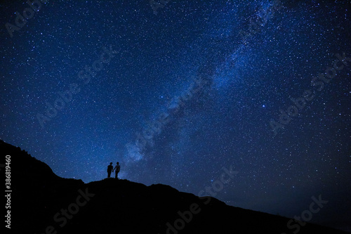 Silhouette of two girls   women on the hill.  Stargazing at Oahu island  Hawaii. Starry night sky  Milky Way galaxy astrophotography.
