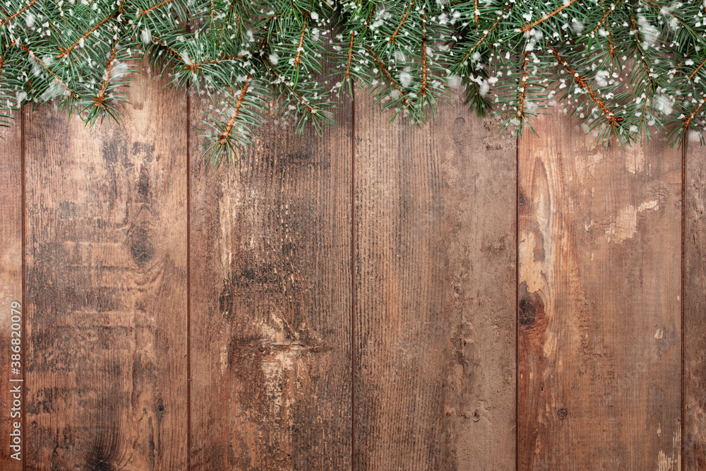 Old wood background with fir branches and snowflakes. Space for a greeting message. Christmas card. Top view. Effect of snowflakes. Old wood background with fir branches and snowflakes. Space for a greeting message. Christmas card. Top view. Effect of snowflakes.