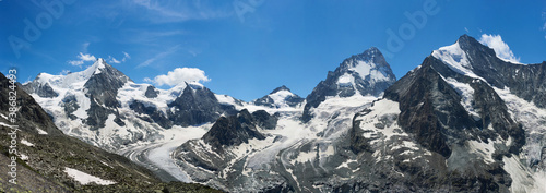 Panorama view of the morning mountain ridge of Pennine Alps, Ober Gabelhorn and Dent Blanche among those sunlit peaks, concept of travelling