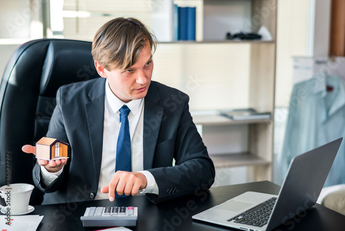 Fotografija Happiness businessman hold house model in hand at office, real estate home inves