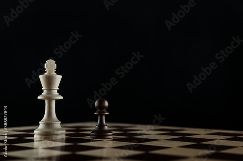 chess pieces are on black background with copy space. king and pawn