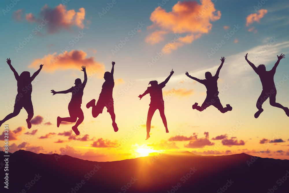 Silhouette happy friends jump at top of mountain on sunset sky abstract background. Copy space of feel good freedom and travel adventure concept.