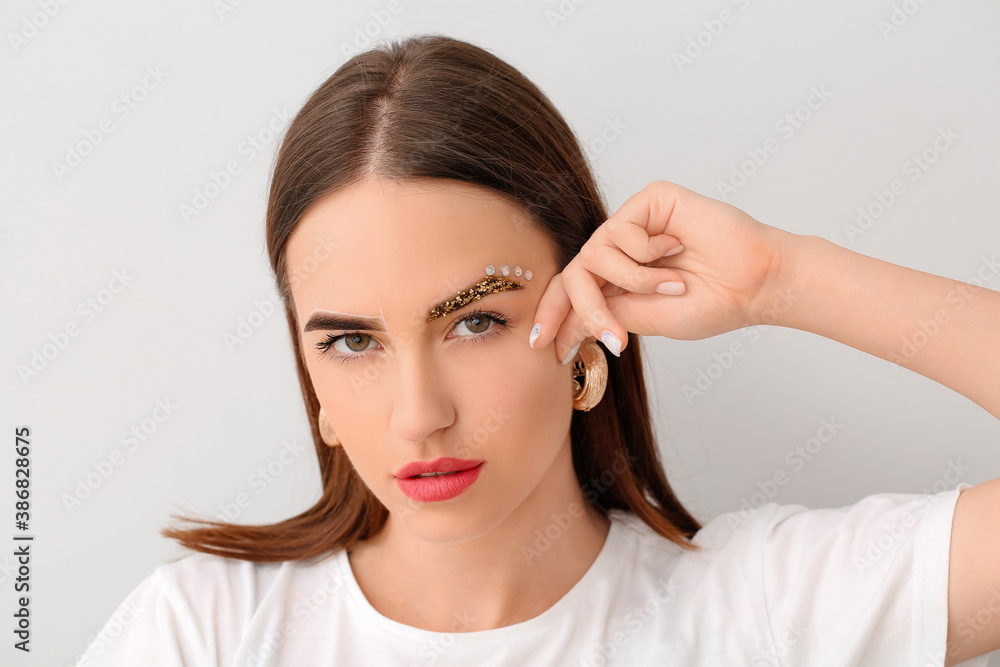 Young woman with creative eyebrows on light background Young woman with creative eyebrows on light background