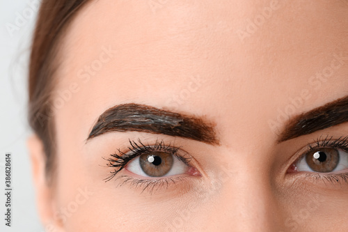 Young woman dyeing eyebrows...