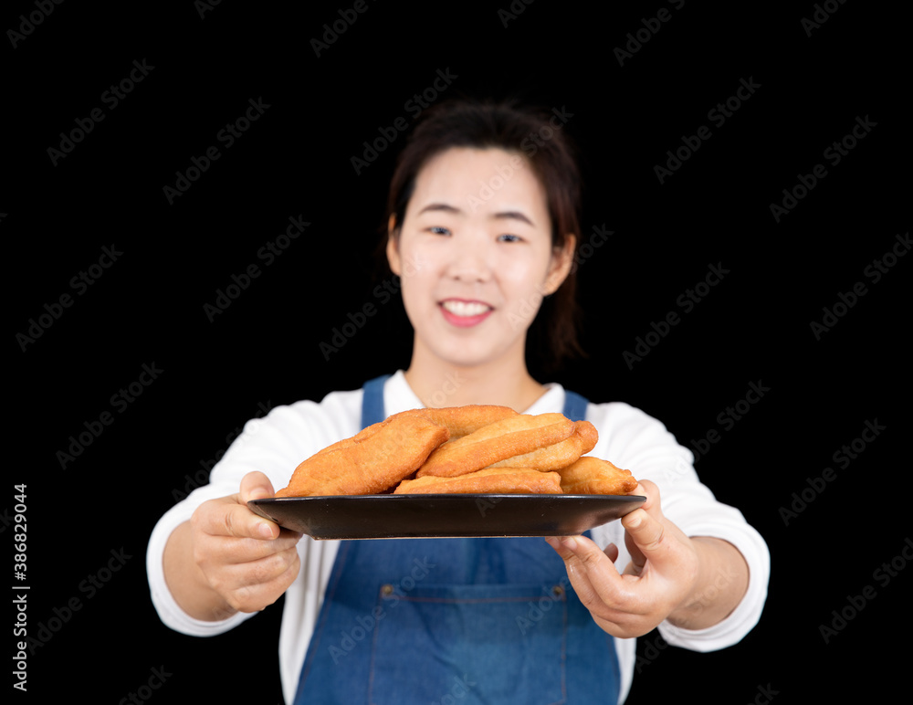 In front of a black background, a gourmet blogger handed fried dough sticks In front of a black background, a gourmet blogger handed fried dough sticks