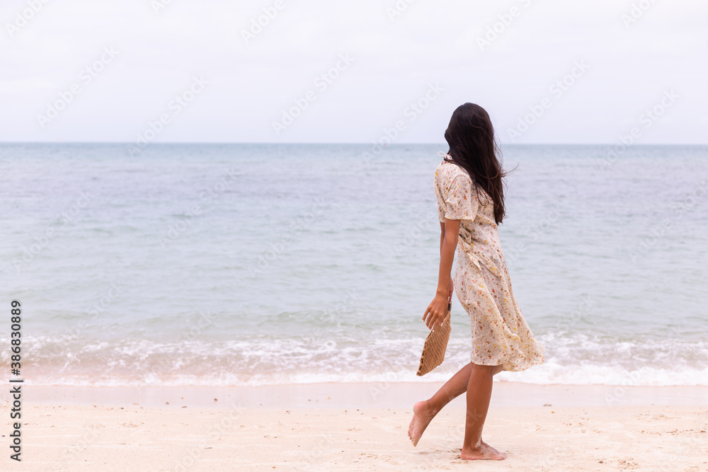 Romantic portrait of woman in long dress on beach at windy cloudy day. Romantic portrait of woman in long dress on beach at windy cloudy day.