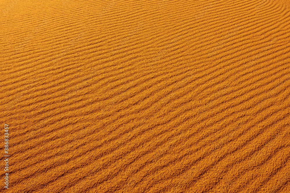 The texture of sand in the desert. Abstract nature background. Sandy dunes at sunset light The texture of sand in the desert. Abstract nature background. Sandy dunes at sunset light