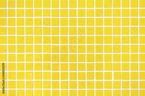 Square yellow ceramic tiles texture. Trendy interior background pattern. 2021 color trend.