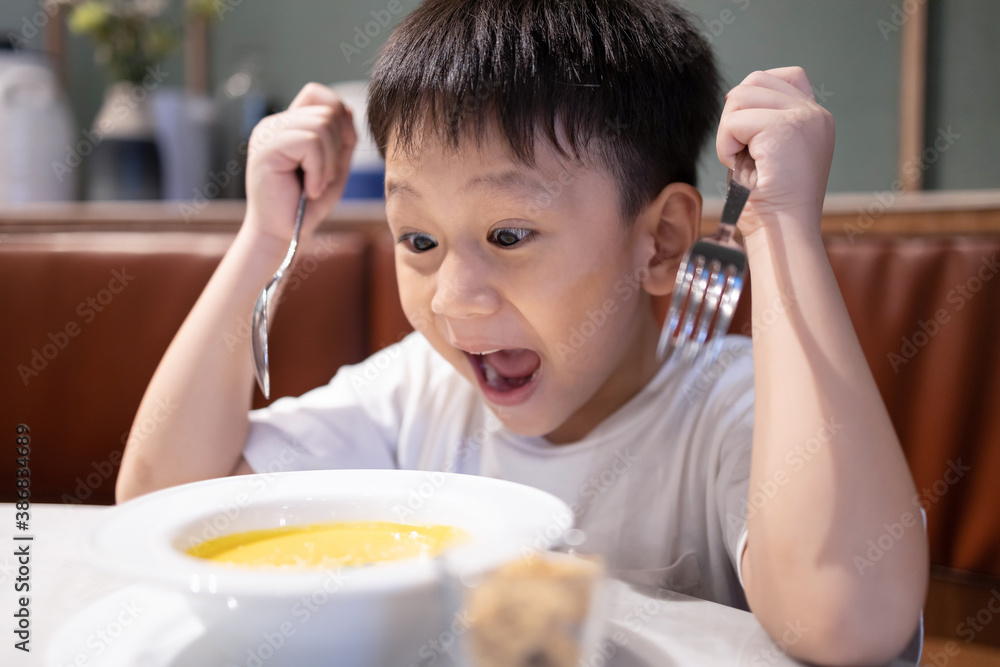 Happy asian kid boy hold spoon and fork,feeling excited and likes to eat,enjoys delicious vegetable soup,child boy with eyes and mouth wide open,tasty food good appetite,healthy meal,nutrition concept Happy asian kid boy hold spoon and fork,feeling excited and likes to eat,enjoys delicious vegetable soup,child boy with eyes and mouth wide open,tasty food good appetite,healthy meal,nutrition concept