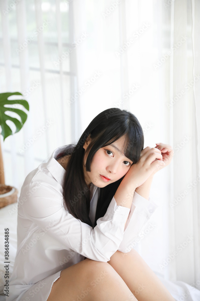 Portrait beautiful asian girl sitting with clock at white bedroom Portrait beautiful asian girl sitting with clock at white bedroom