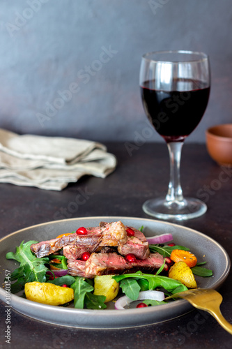 Grilled beef steak salad with arugula, potatoes, carrots, onions and pomegranate. Healthy eating. Diet.