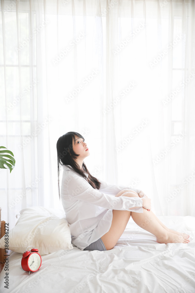 Portrait beautiful asian girl sitting with clock at white bedroom Portrait beautiful asian girl sitting with clock at white bedroom