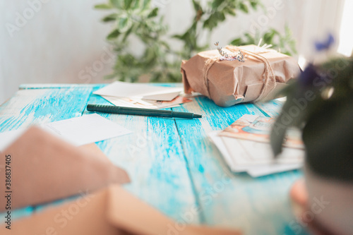 Vintage composition of postcards, pen and parcel. Side view. Blue wooden background. Concept of post mail photo