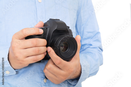 Close-up of photographer holding SLR camera in hand