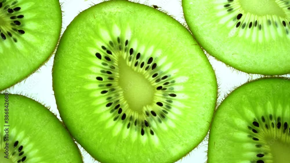 Top view Rotate of Transparent Slice of kiwi fruit on white background, Close up fresh kiwi sliced on white background and slowly rotating. Top view Rotate of Transparent Slice of kiwi fruit on white background, Close up fresh kiwi sliced on white background and slowly rotating.