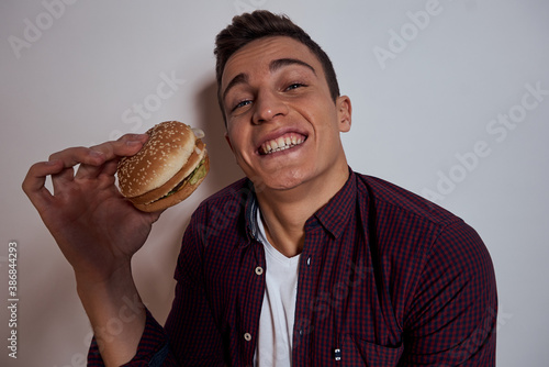 man holding near face hamburger diet food hunger lifestyle fast food light background