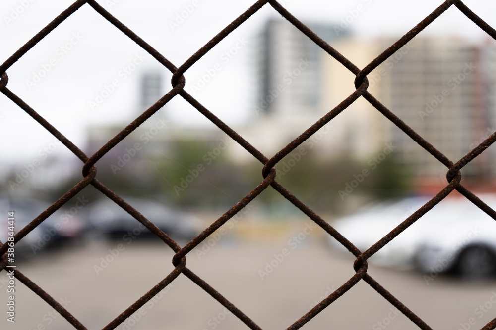 chainlink fencing around a car parking area. detail, close up of rusty wire. chainlink fencing around a car parking area. detail, close up of rusty wire.