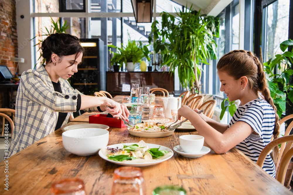 Mother and daughter enjoing themselves in a cafe. Mother and daughter enjoing themselves in a cafe.