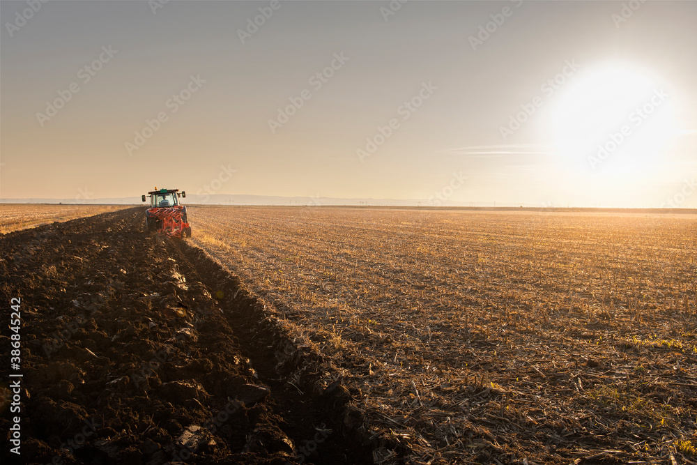 Tractor on the field during sunset. Tractor on the field during sunset.