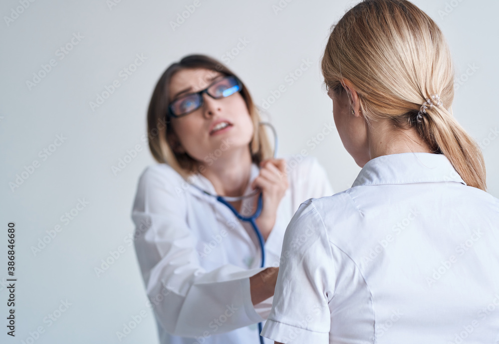 professional woman doctor in medical gown and glasses blue stethoscope patient professional woman doctor in medical gown and glasses blue stethoscope patient