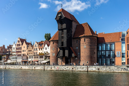 The largest medieval port Crane in Europe and historic buildings on the Dlugie Pobrzeze over the Motlawa River in Gdansk, Poland.
