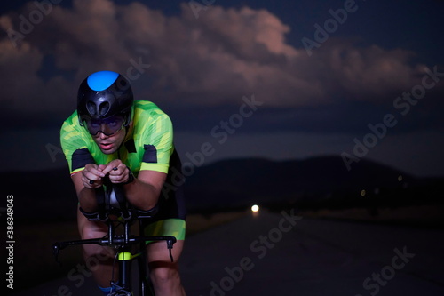 Fototapeta Naklejka Na Ścianę i Meble -  triathlon athlete riding bike fast at night